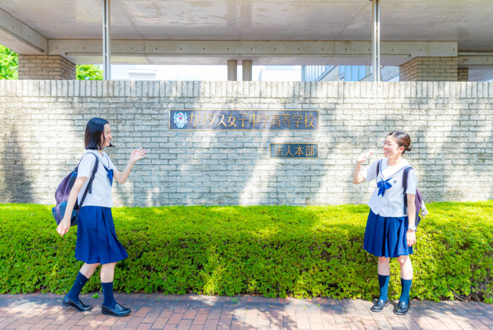 カリタス女子中学高等学校の校門前の生徒2名