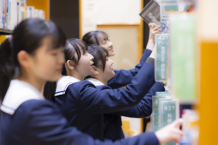 カリタス女子中学高等学校の生徒たちの図書館での調べ学習風景