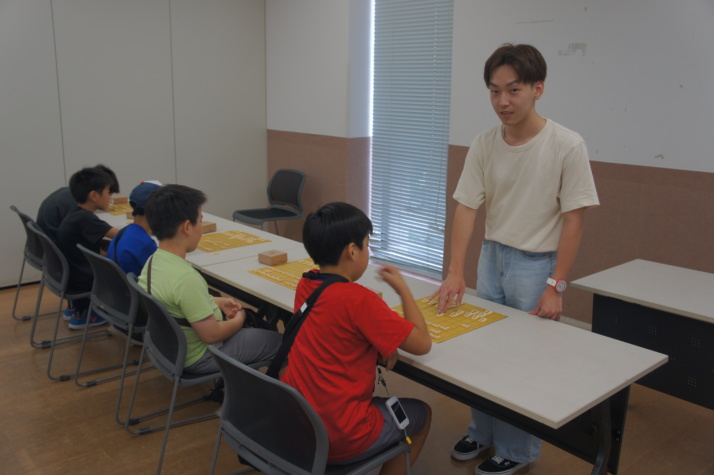 「調布ジュニア将棋教室」で大学生から指導を受ける子どもたち