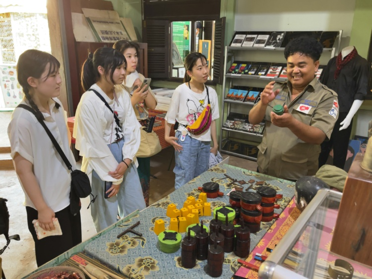 普連土学園中学校・高等学校の生徒らがカンボジアの地雷博物館でアキ・ラーさんの説明を聞くようす