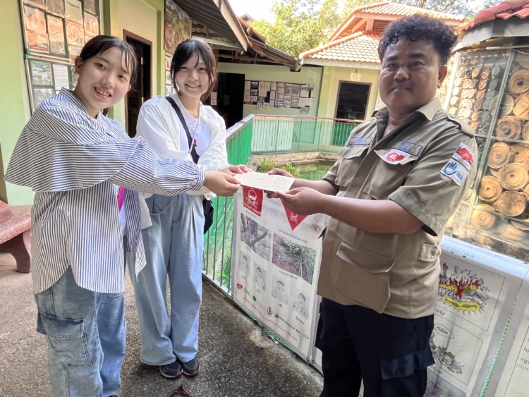 普連土学園中学校・高等学校の生徒がアキ・ラーさんに献金を渡すようす