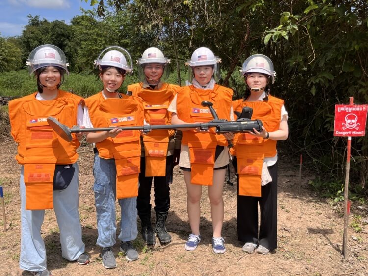 普連土学園中学校・高等学校の生徒らがカンボジアの地雷撤去の現場で探知機を持つようす