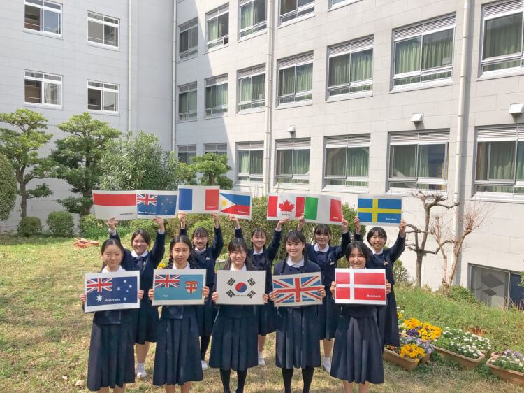 福岡雙葉中学校・高等学校でさまざまな国の国旗を持つ生徒たち