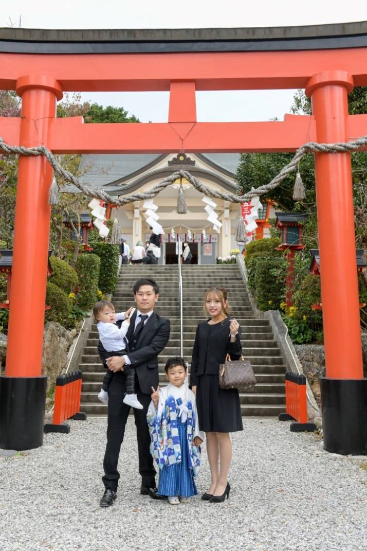 「二川伏見いなり」本殿と鳥居を背景に七五三詣のご家族