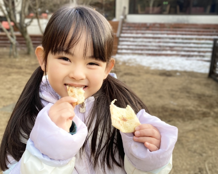 山梨県北杜市にある「1000Mのおもてなし 八ヶ岳ホテル風か」でウェルカムピザを食べる子ども