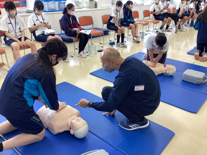 中部大学春日丘中学校の中大連携プログラム（応急処置を指導する様子）