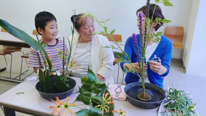 先生にアドバイスをもらいながら花を生ける親子