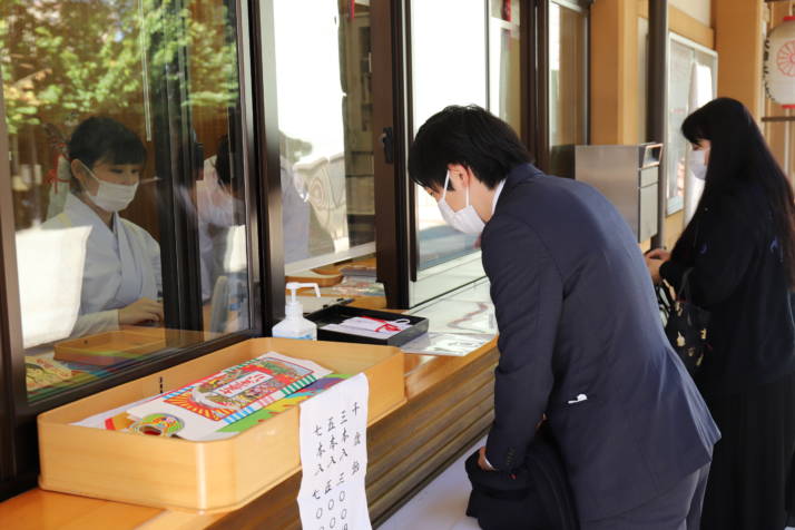 居木神社の社務所で七五三詣の受付をする参拝客