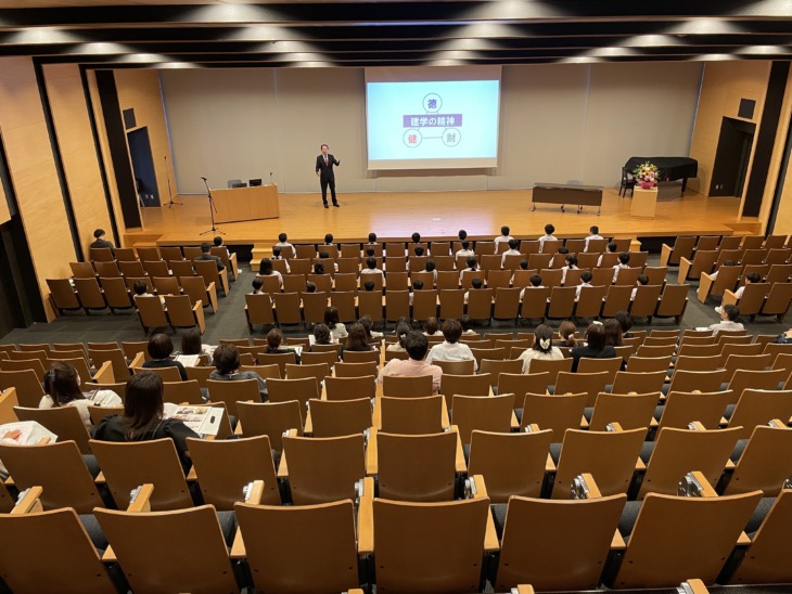 講堂に集まる城南学園小学校の児童と保護者