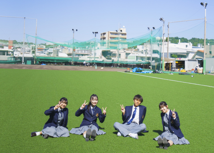 グラウンドに座る興南中学校・高等学校の生徒たち