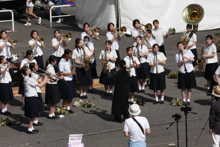 活水中学校・高等学校の吹奏楽部が屋外で演奏している様子