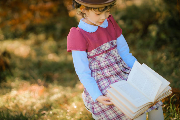 外で読書をしている女の子の写真