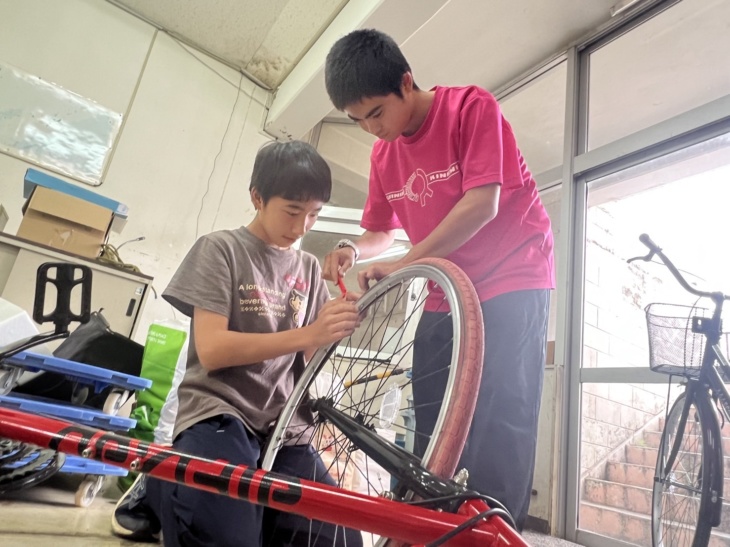 労作学習で自転車の修理に取り組む沖縄三育中学校の生徒たち