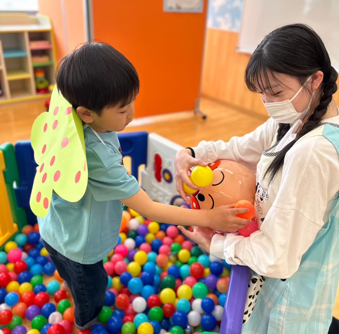 こどもんくらぶのボールプールで遊ぶ子どもと保育学生