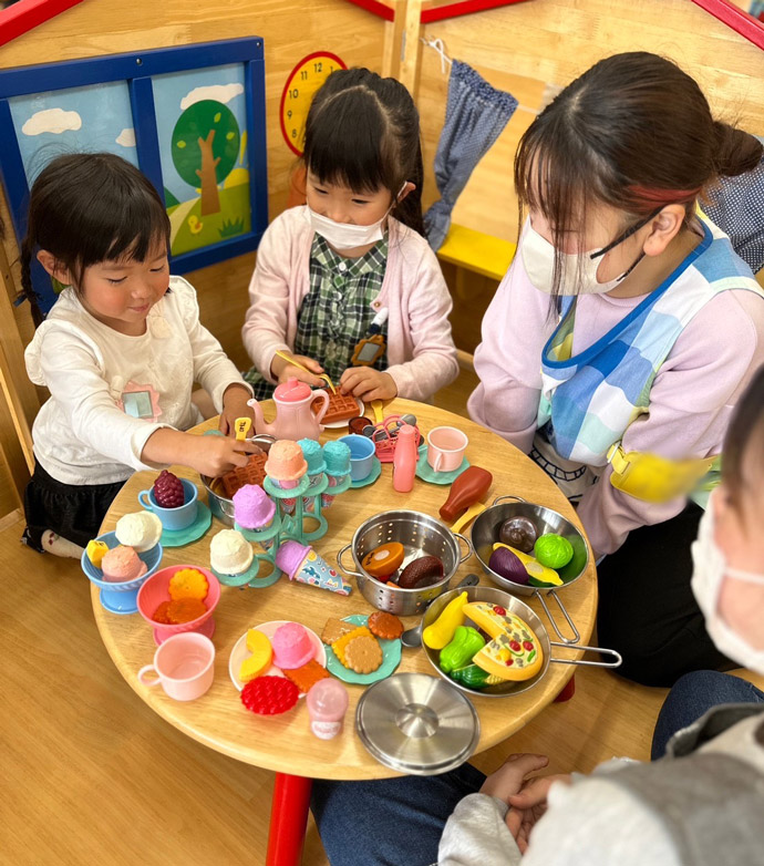 こどもんくらぶでおままごとをする子どもと保育学生