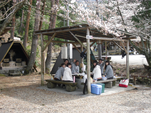 高取山ふれあい公園キャンプ場でお花見をしながらバーベキューを楽しむ人々