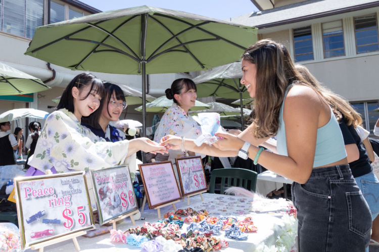 瀧野川女子学園中学高等学校のハワイの修学旅行で実施するチャリティーバザーで自ら開発した渾身の新商品を販売する女子生徒たち