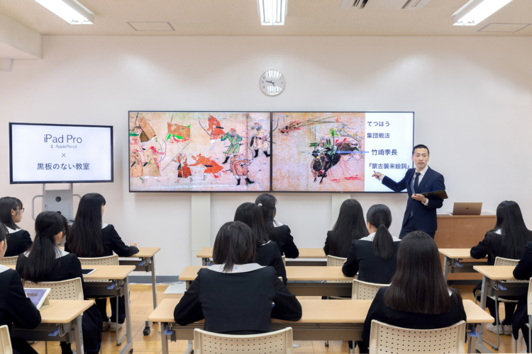 瀧野川女子学園中学高等学校の黒板の無い教室で授業を受ける女子生徒たち