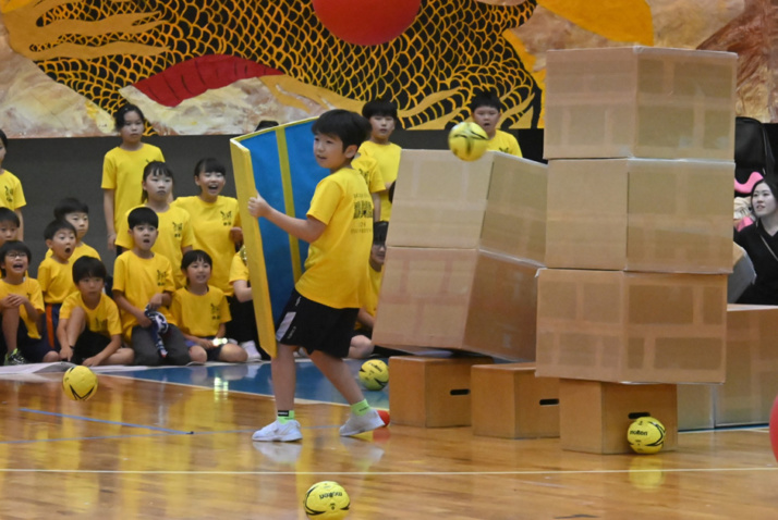 山梨学院小学校の児童が城壁を壊す競技に挑戦するようす